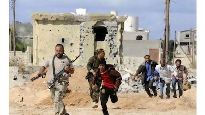 Libya's National Transitional Council fighters escort civilians fleeing Sirte during heavy fighting Monday.