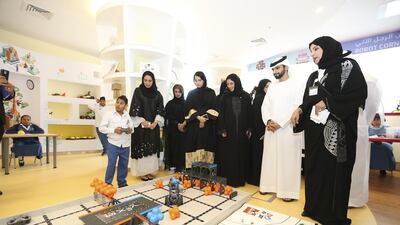 Some of the children at the centre show Sheikh Mansour bin Mohammed bin Rashid some of the technology, robots and solar powered tools that will help them integrate. Courtesy Dewa