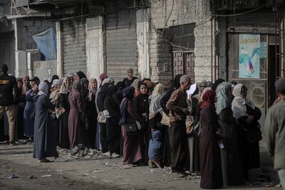 Palestinians wait for access to a Bank of Palestine branch that has reopened in Gaza city. Bloomberg