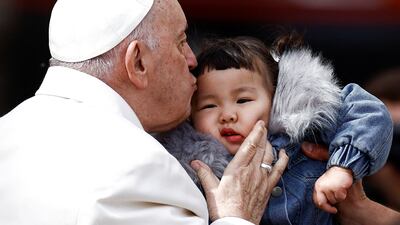 Pope Francis kisses a child at his weekly general audience in St Peter's Square at the Vatican. Reuters
