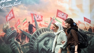 Iranians walk past an anti-US billboard in Tehran. EPA