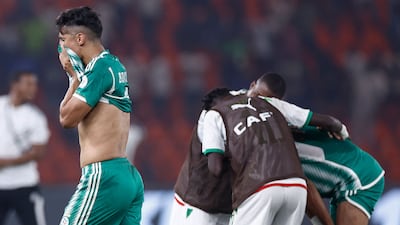 Algeria's Baghdad Bounedjah leaves the field dejected as Mauritania celebrate their win. AFP