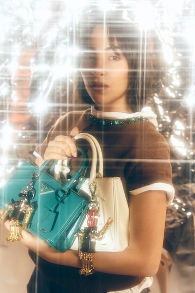 Wool and cashmere crew-neck sweater; satin shorts; cotton jersey T-shirt; Galleria leather bags; and Robot Saffiano leather key ring charms, all from Prada