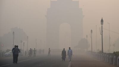 Pedestrians walk through heavy smog near the India Gate monument in New Delhi on October 20, 2017, the day after the Diwali festival. Dominique Faget / AFP