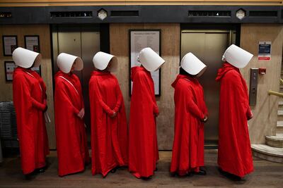 People dress up as characters from Margaret Atwood's "The Handmaid's Tale" queue to get a copy of her new novel 'The Testaments' at Waterstones bookshop in London. Reuters.