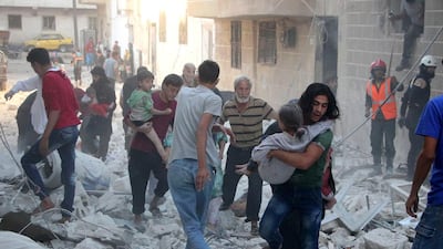 Syrian men carry the injured amid the rubble of buildings destroyed by an air strike on the rebel-held northwestern city of Idlib on September 29, 2016 The Syrian Observatory for Human Rights said at least five air strikes hit various areas of the city. Omar Haj Kadour / Agence France-Presse