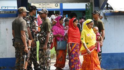 Paramilitary personnel stand guard as voters in Kolkata come and go at a polling station during West Bengal's local elections