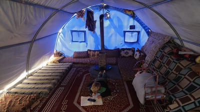 Internally displaced boy, Mahmoud Abdel Hadi, 8, does his homework received on mobile, inside his tent after his tented school was shut due to the threat of coronavirus disease in Atmeh camp, near the Turkish border, Syria. Reuters