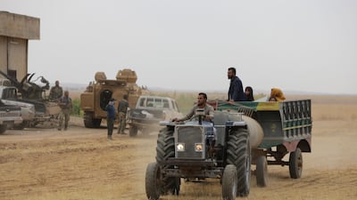 Syrians ride in the back of a farmer's truck as they flee villages where fighting continues in the countryside of Tal Abyad. AFP