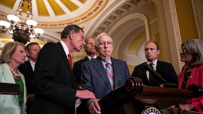 Senator John Barrasso reaches out to help Senate minority leader Mitch McConnell after he froze and stopped talking in Washington on July 26. AFP