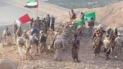 Pro-government forces and Arab coalition troops raise the flags of the UAE, Saudi Arabia and Bahrain on a hill above the Marib Dam on September 29. The dam was captured from Houthi rebels on September 28 . Photo courtesy of the Yemeni military