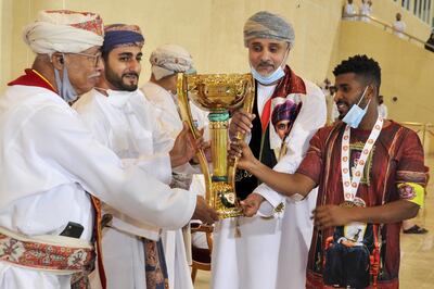 Omani Minister of Sport Sayyid Dhi Yazan bin Haitham (2nd-L) presents the trophy to Dhofar players after they won a football match, the Sultan Qaboos Cup final, in the Omani capital Muscat on November 29. AFP