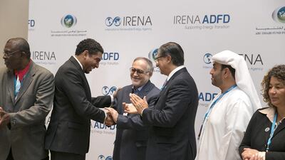 Adel Al Hosani, second right, the Abu Dhabi Fund for Development director of operations, looks on as Irena director general Adnan Amin, congratulates the Iranian delegation for being selected as one of five countries that will receive a loan for renewable energy projects. Silvia Razgova / The National