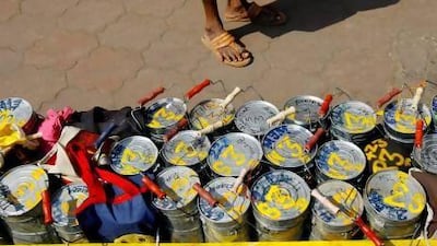 A Mumbai dabbawala, or lunch-box deliveryman, stands next to a crate of tiffin boxes in Mumbai. Sajjad Hussain / AFP Photo