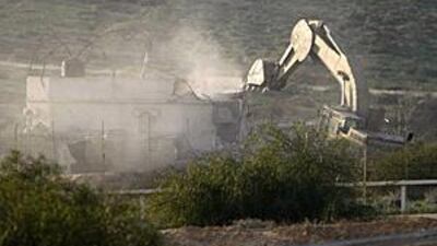 n Israeli bulldozer demolishes a Palestinian house on the Israeli-Gaza border.
