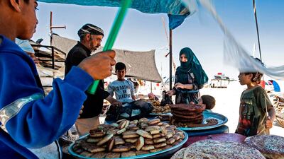 Displaced Syrians wait for their order of sweets at the Washukanni camp for the internally displaced in Syria's northeastern Hasakeh province, during Ramadan. AFP