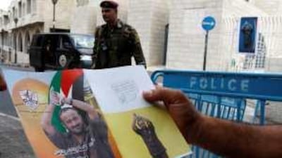 A man holds up a placard depicting Marwan Barghouthi. Mr Barghouthi, who is serving a life sentence in an Israel jail, was one 14 new members to be elected.