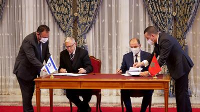 Unidentified Moroccan and Israeli officials sign memorandums of understanding during a visit by Israeli envoys to Rabat, Morocco. REUTERS