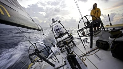 Luke Parkinson of Abu Dhabi Ocean Racing mans the helm as Azzam sails through the Singapore Straits on Thursday. Matt Knighton / Abu Dhabi Ocean Racing / Volvo Ocean Race / January 22, 2015