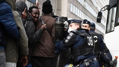 Migrants are restrained by riot police on November 4, 2016, during the evacuation of a makeshift camp near Stalingrad metro station in Paris, one of several sprouting up around the French capital. Over 2,000 migrants were moved by police from the Paris town centre to a legal migrant camp. Lionel Bonaventure / Agence France-Presse