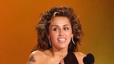 Miley Cyrus wears Tom Ford to accepts the Record Of The Year award. AP