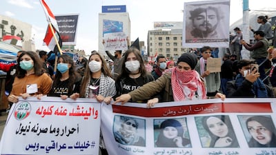 Women carry pictures of demonstrators who were killed during protests in Baghdad. REUTERS