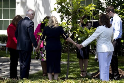 US President Joe Biden and his wife Jill pray with family members of service people who have died in combat, during a tree-planting ceremony on the South Lawn of the White House in Washington on Monday. Bloomberg
