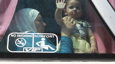 Syrian refugee Umm Luay, 30, sits with her child inside a bus on September 17, 2018 as she returns with her family to Syrian after living as refugees in Lebanon for years. AFP