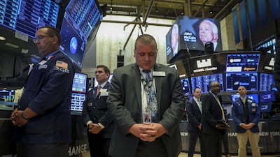 Traders observe a moment of silence for the late US Senator John McCain prior to the opening bell on the floor of the New York Stock Exchange. Drew Angerer / Getty Images / AFP