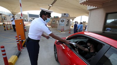 An immigration officer assists an American national in a car as he arrives at a medical checkpoint while crossing from Saudi Arabia into Bahrain. Reuters