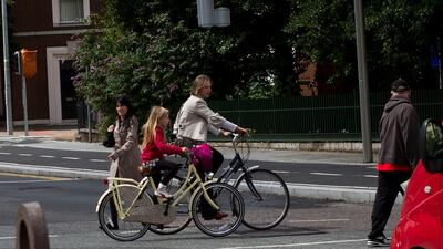 A mother and daughter cycle to school in Dublin, Ireland. Local Caption