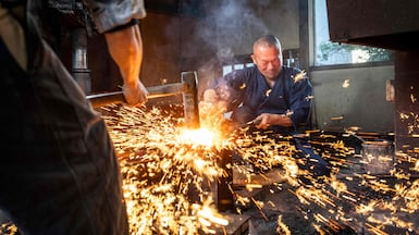 Sparks fly as swordsmith Akihira Kawasaki, right, steadies steel over an anvil while his apprentice Toru Watanabe hammers the metal to forge katana blades, at Kawasaki's workshop in Misato, Saitama prefecture, Japan. AFP