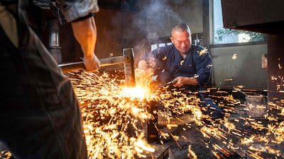 Swordsmith Akihira Kawasaki, right, and apprentice Toru Watanabe at work in Saitama prefecture, Japan. AFP