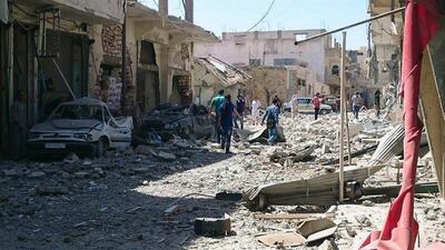 Syrians inspect damaged houses following a Syrian government airstrike in the north-eastern city of Raqqa, on Saturday. Syria launched a series of airstrikes targeting Raqqa on Saturday, killing dozens people, most of whom died when one of the missiles slammed into a crowded bakery, activists said. Raqqa Media Center of ISIL / AP Photo