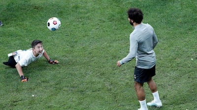 Mohamed Salah plays football with a child during training in Istanbul. Reuters