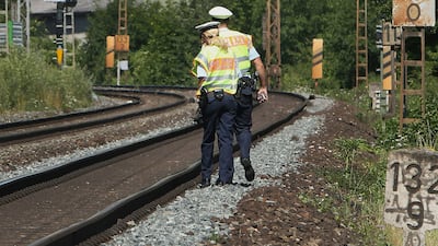 Police officers walk along train tracks in Wuerzburg, southern Germany, a day after a man attacked train passengers with an axe. (AFP / DANIEL ROLAND)