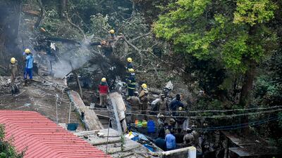 Firemen and rescue workers try to control the fire in the burning debris of the helicopter crash site. AFP