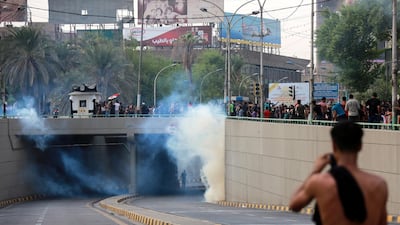Iraqi protesters run for cover amid tear gas fired by policemen during a demonstration at Tahrir Square, central Baghdad. EPA