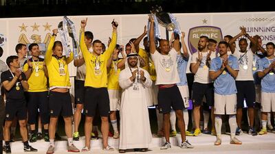 Manchester City captain Vincent Kompany lifts the English Premier League trophy after his team's friendly against Al Ain at the Hazza bin Zayed Stadium on May 15, 2014. Satish Kumar / The National