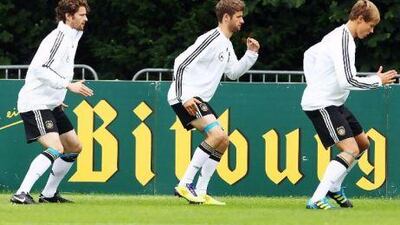 Germany's Arne Friedrich, left, Thomas Muller, centre, and Holger Badstuber take part in training at the team's camp in Frankfurt ahead of tonight's match with Group A rivals Austria.