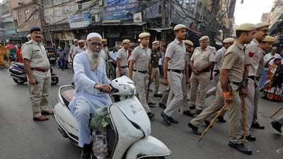 A man rides a scooter past police officers conducting outside the Jama Masjid in Delhi before Supreme Court's verdict on the disputed Ayodhya site. Reuters