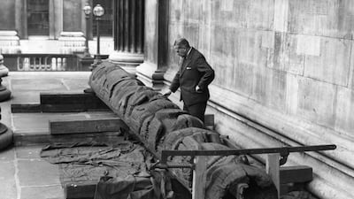 A man examines a totem pole which was purchased from a village in British Columbia and brought to the museum in 1933