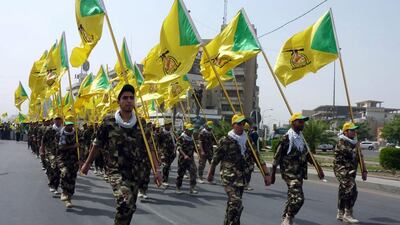 Supporters of Iraqi Hezbollah scouts carry their party's flag and parade during a rally to mark Jerusalem Day in Baghdad (EPA/ALI ABBAS)