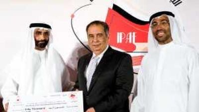 Mohammed Ahmad al Bowardi, the Secretary General of the Executive Council, left, and Ahmed Ali al Sayegh, the managing director of the Emirates Foundation, award the author Yusuf Zeydan for his novel Beelzebub.