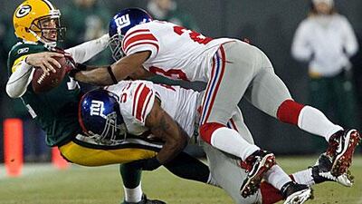 Aaron Rodgers of Green Bay is sacked by New York Giants' Michael Boley, center, and Corey Webster.