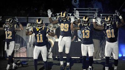 Members of the St Louis Rams raise their arms in solidarity with protesters in Ferguson, prompting criticism from the St Louis Police Officers' Association. LG Patterson/AP Photo