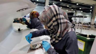 A technician applies final touches to a flap track fairing at Strata in Al Ain. Reuters