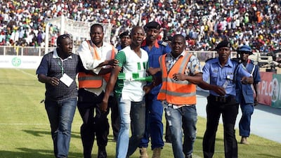 Security officials evacuate a man (C) who tried to hug Nigerian players during the African Cup of Nations qualification match between Egypt and Nigeria, on March 25, 2016, in Kaduna. AFP / PIUS UTOMI EKPEI