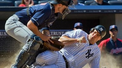 New York Yankees runner Mark Teixeira scores as Cleveland Indians catcher Lou Marson tries to control the ball.
