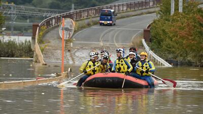 Emergency personnel paddle across floodwaters. AFP